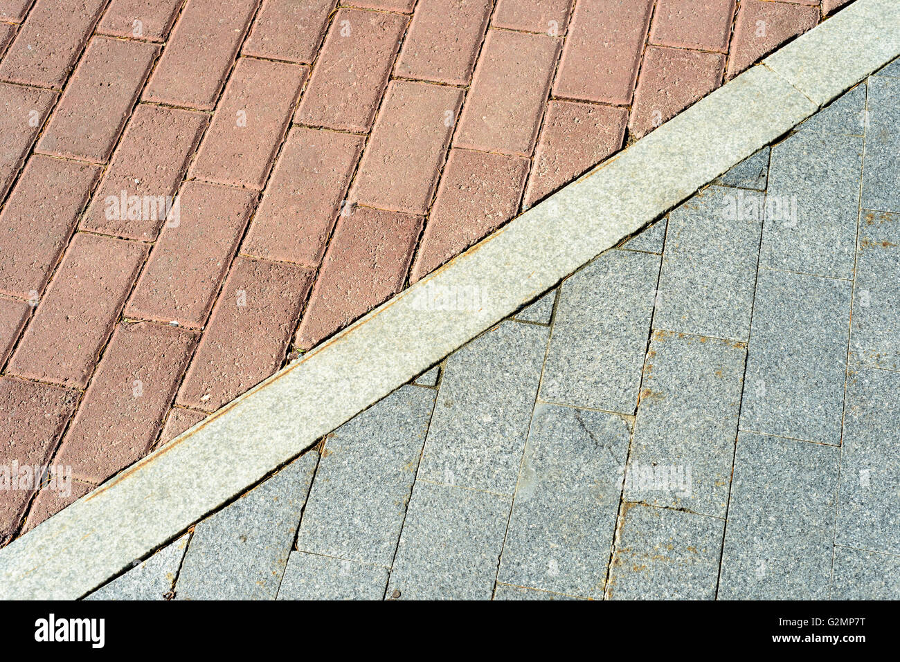 Red and grey pavement bricks separated by white concrete. Stock Photo