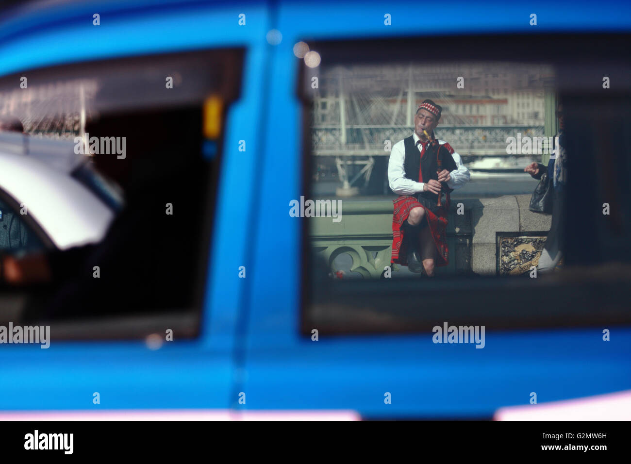 A view, through the windows of a taxi, of a street entertainer playing ...