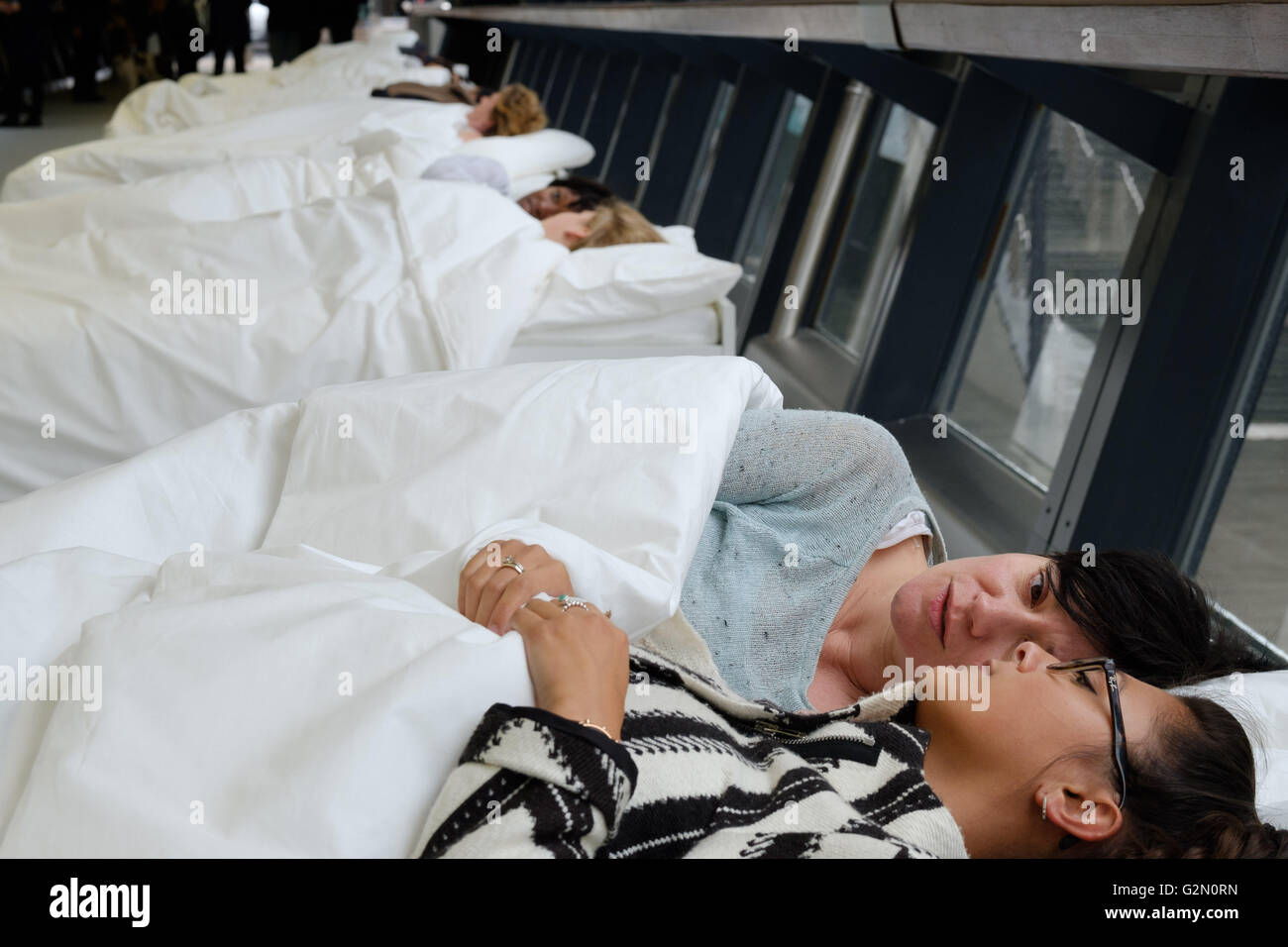 EDITORIAL USE ONLY Everything by my side, a theatrical performance that sees actors in white beds whisper to individual audience members, created by Argentinian artist Fernando Rubio, is unveiled as it makes its UK debut at Canary Wharf in London. Stock Photo