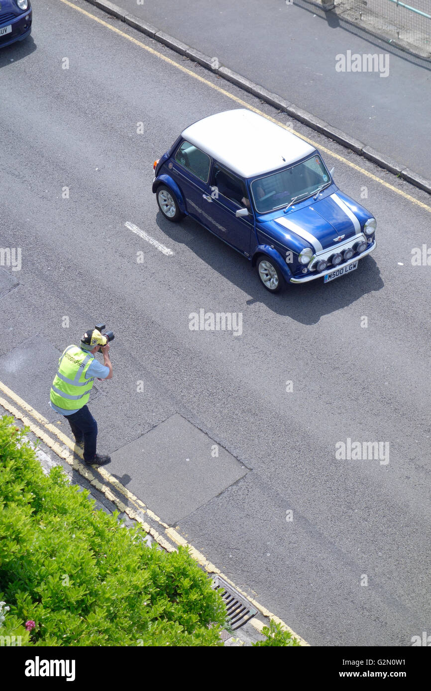 An official photographs the driver of a Rover Mini Classic S500 (2001) arriving at Brighton after completing the 2016 London-Bri Stock Photo