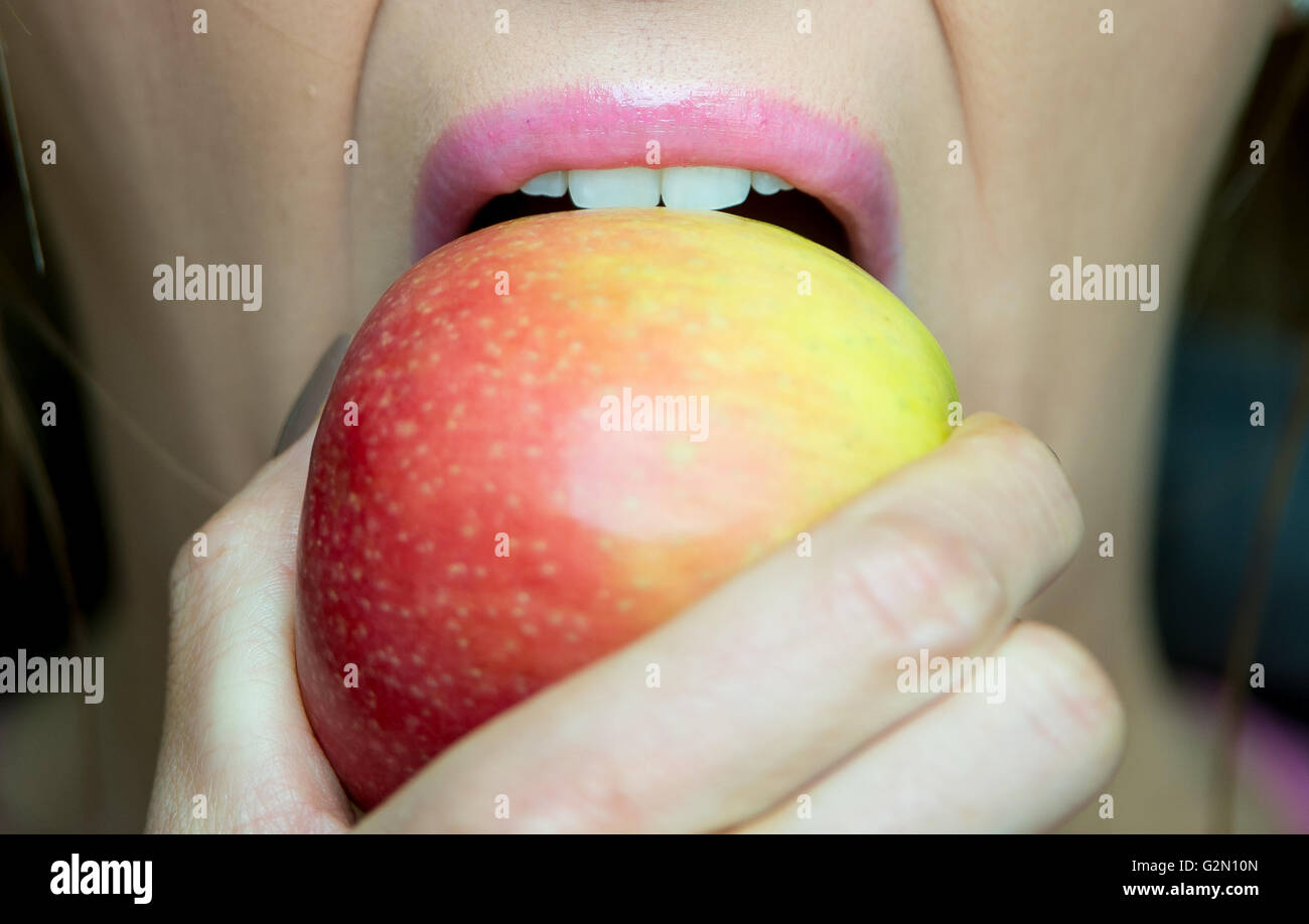 A woman biting into an apple Stock Photo