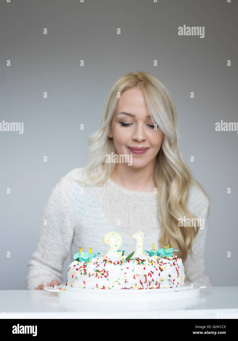 Portrait of a young beautiful blond girl holding plate with birthday ...