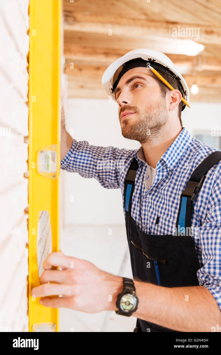 Closeup of a construction worker checking the level on the wall
