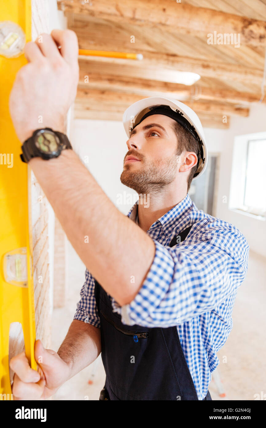 Close-up portrait of a construction builder holding yellow tape at the working area Stock Photo