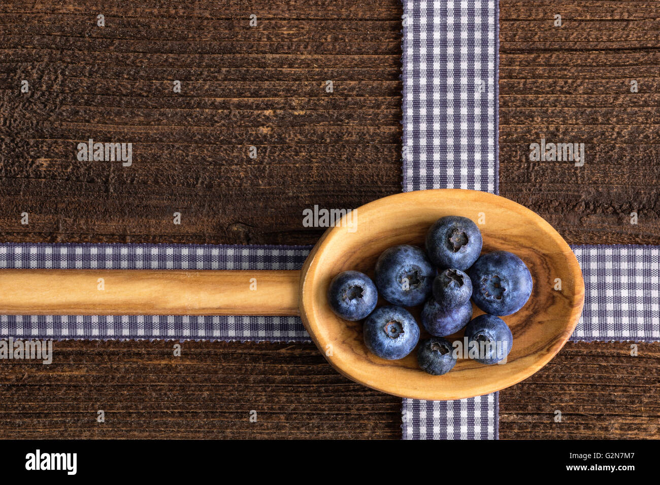 Rustic background with blueberry  on a wooden spoon on a rustic table. Stock Photo