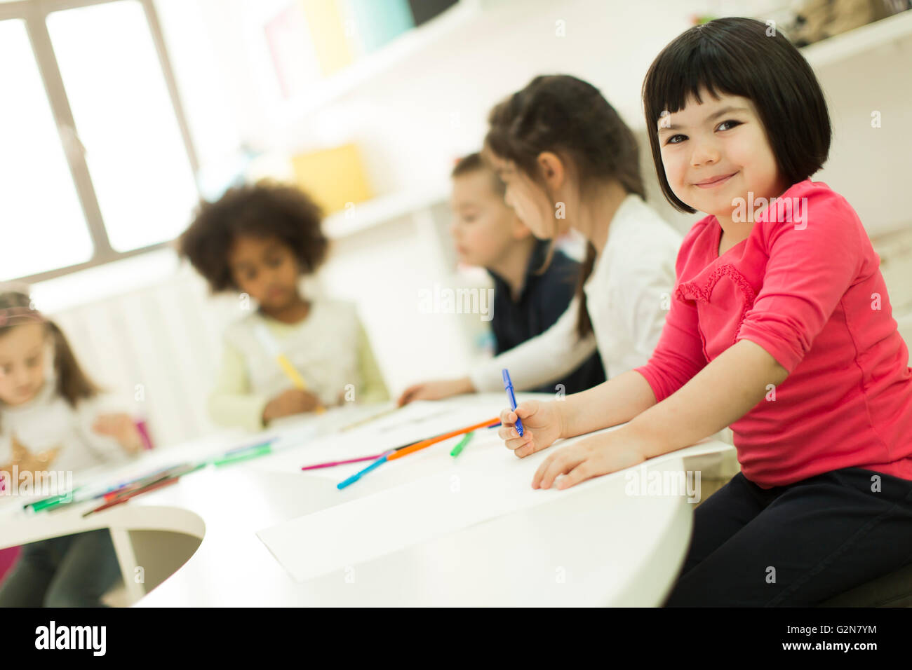 Little girls drawing and learning in the kindergarten Stock Photo