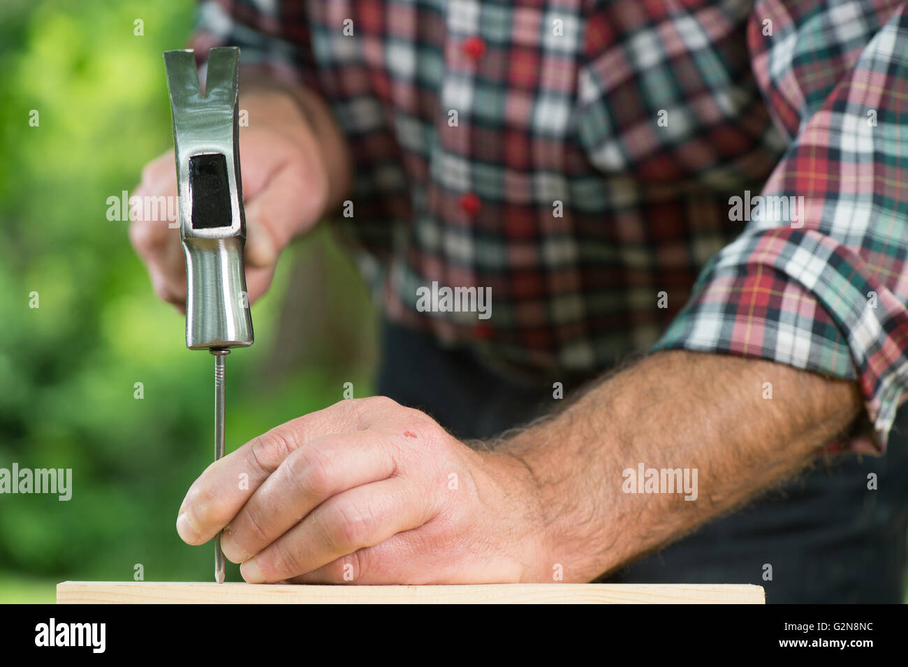 Man hammering nail outdoor Stock Photo
