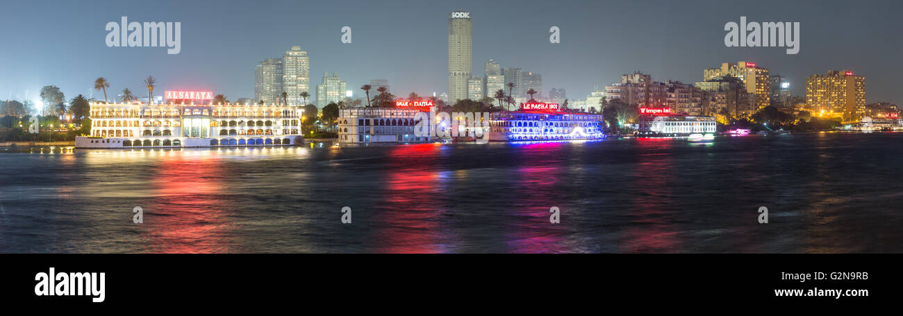 Panoramic view of the Island of Zamalek in central Cairo at night, with it's famous boat restaurants on the Nile river. Stock Photo