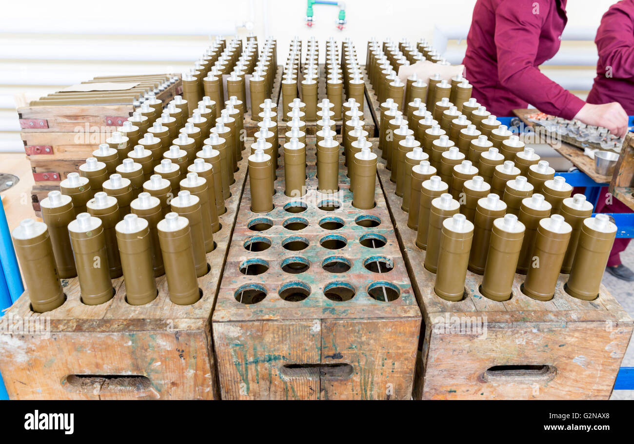 RPG explosive elements of anti tank rocket-propelled grenades (RPGs, bazooka) near an assembly line in a munition factory. Worki Stock Photo