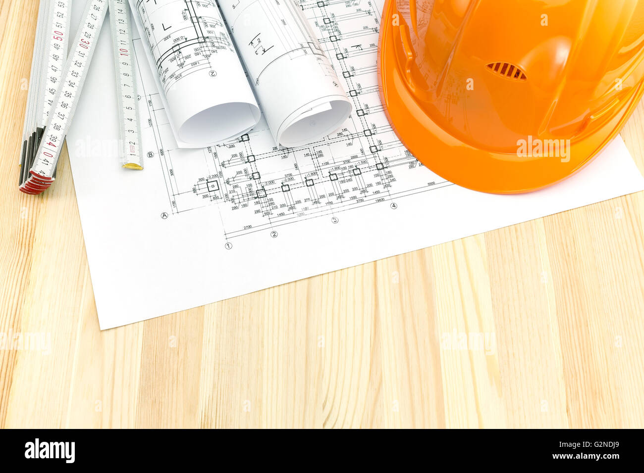 safety helmet and wooden ruler on top of architectural blueprints Stock ...