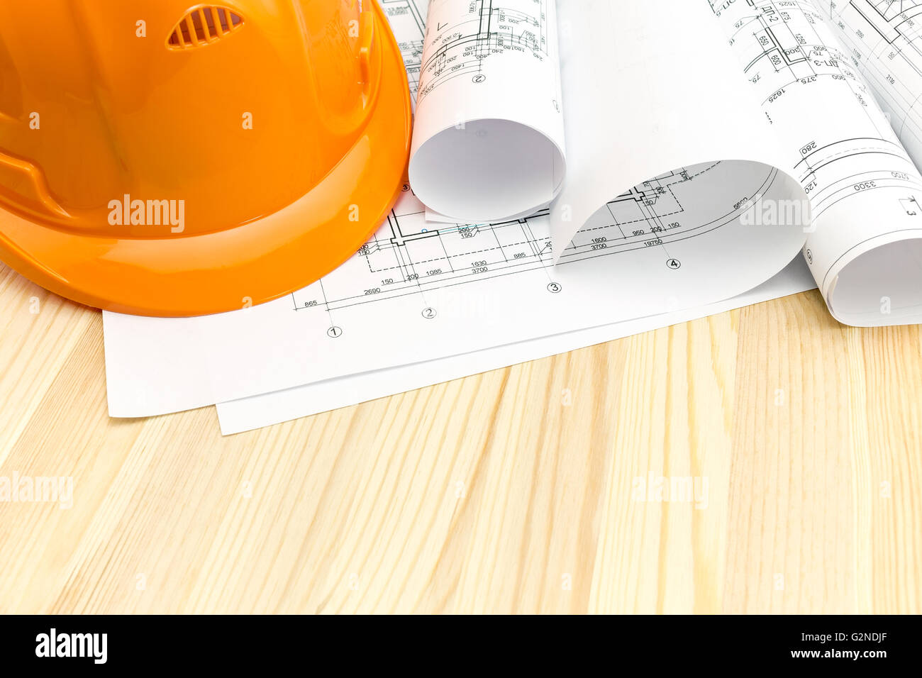 architectural blueprints with rolls of plans and safety helmet on ...