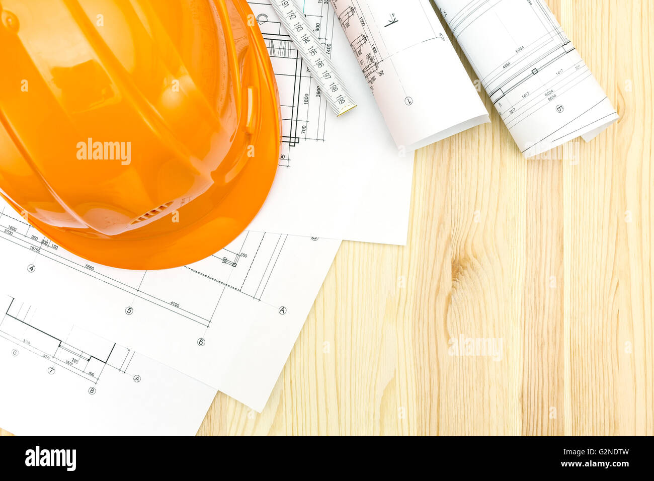 rolls of blueprints with wooden ruler and safety helmet Stock Photo - Alamy