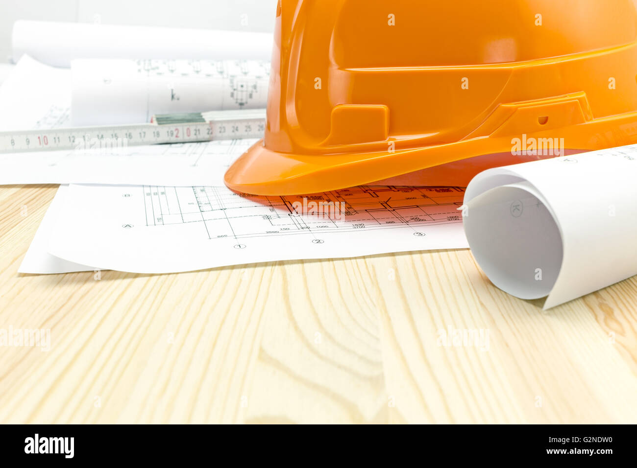 protective helmet with wooden ruler and architectural drawings Stock ...