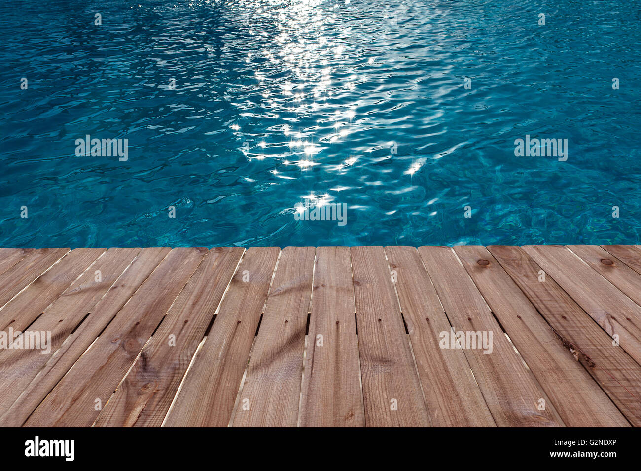 Old wooden floor and blue water in swimming pool Stock Photo