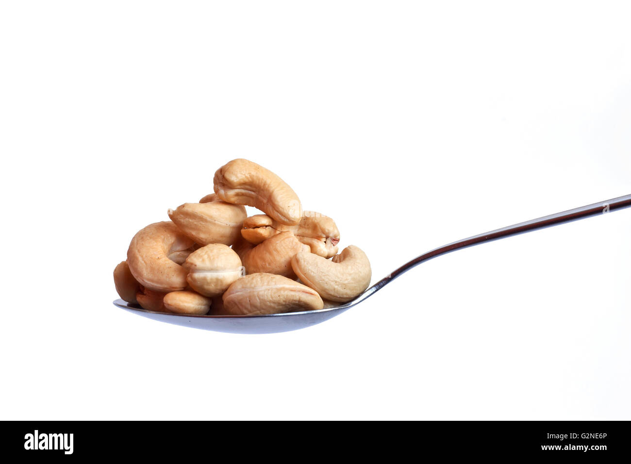 Spoonful of cashew nuts on white background Stock Photo