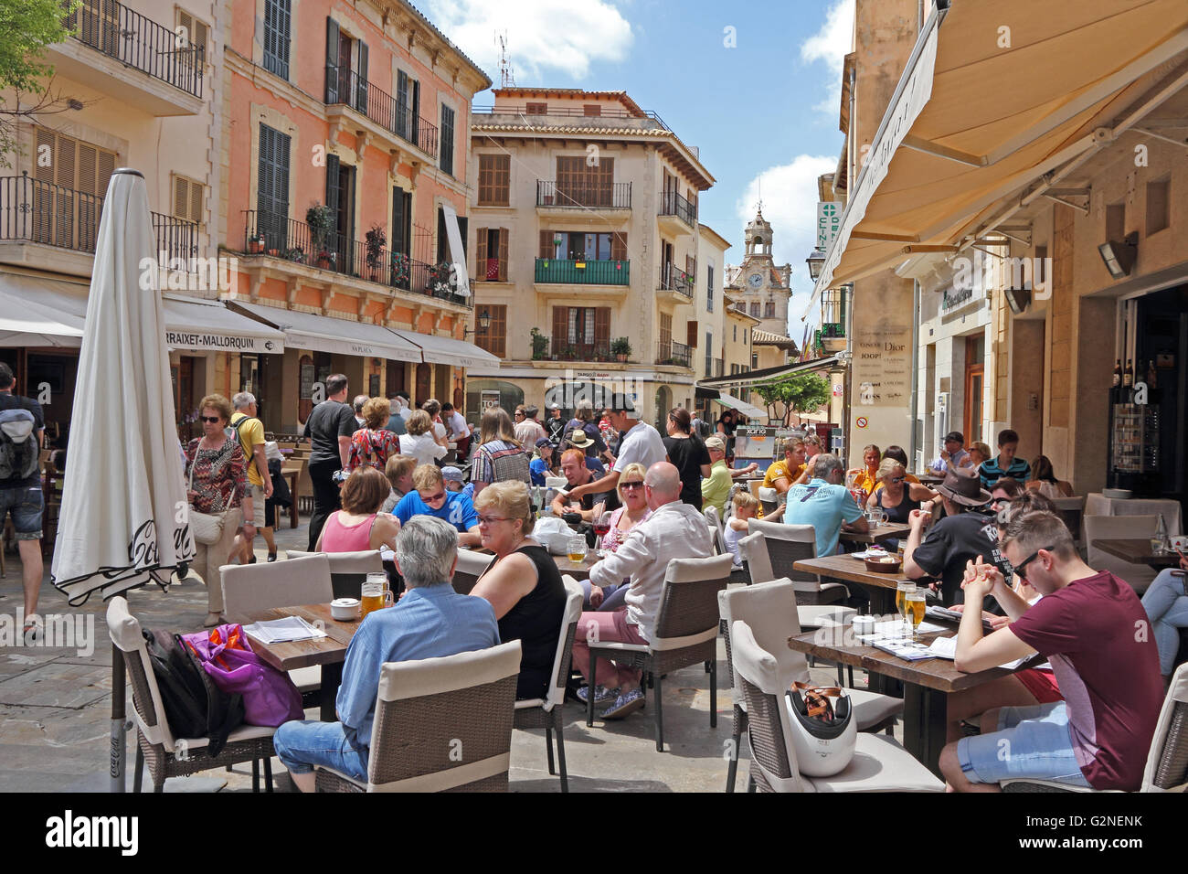 People sat outside cafés in Placa de la Constitucio, Alcudia, Mallorca Stock Photo