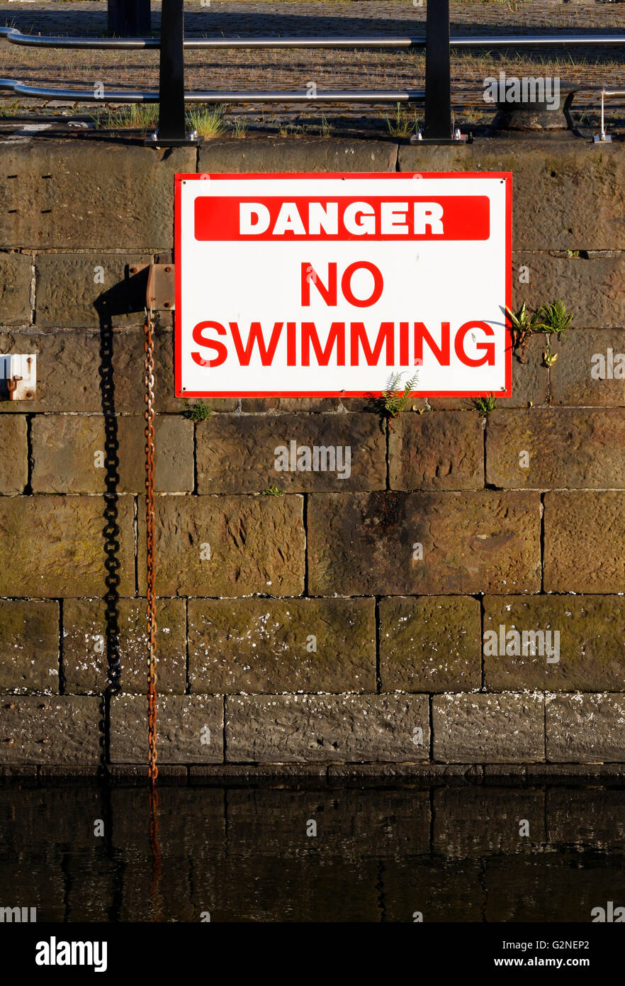 Danger no swimming sign on a wall in a marina Stock Photo