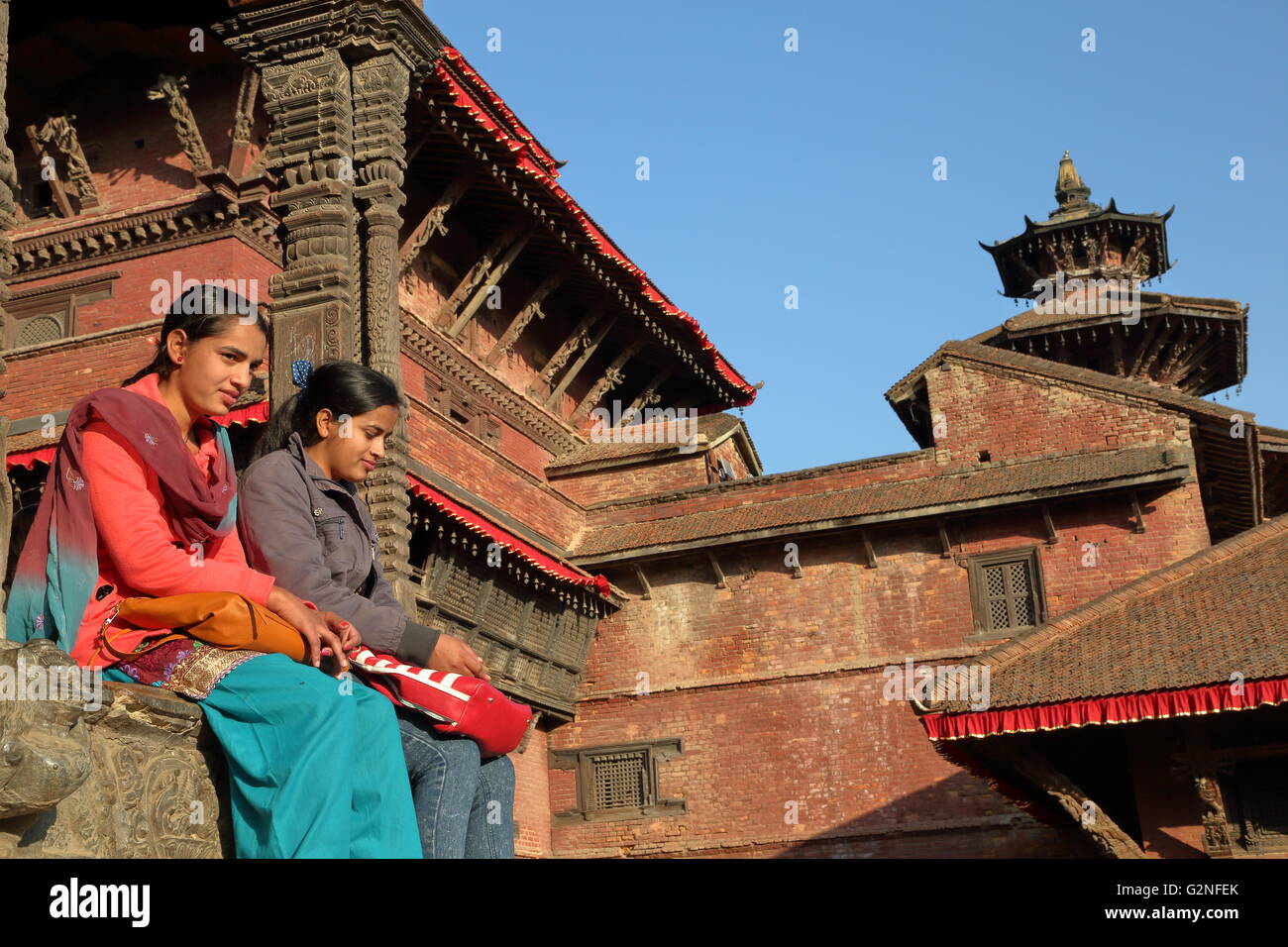 Two young Nepalese women sitting at Durbar Square, Patan, Nepal Stock Photo