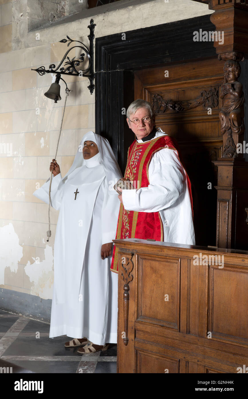 Nun ringing a bell at the beginning of catholic mass in a medieval