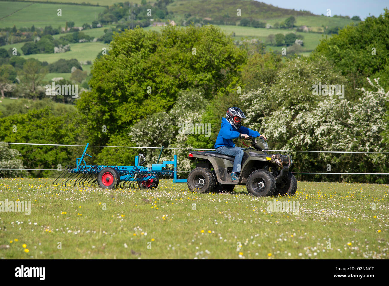 Boy harrowing a field with his quad bike on a sunny summer day Stock
