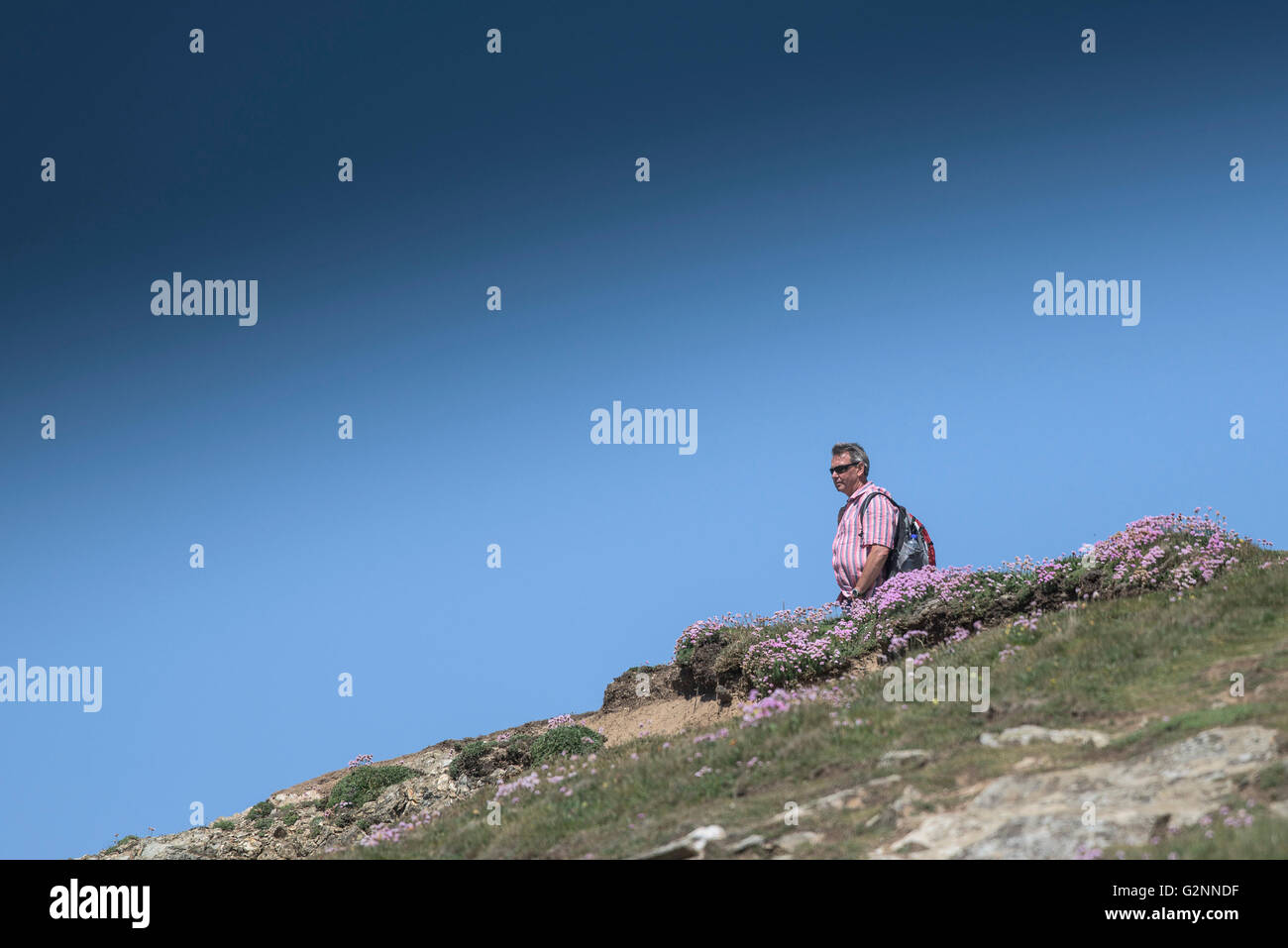 Sunny weather as a holidaymaker stands on East Pentire Headland in Newquay, Cornwall. Stock Photo