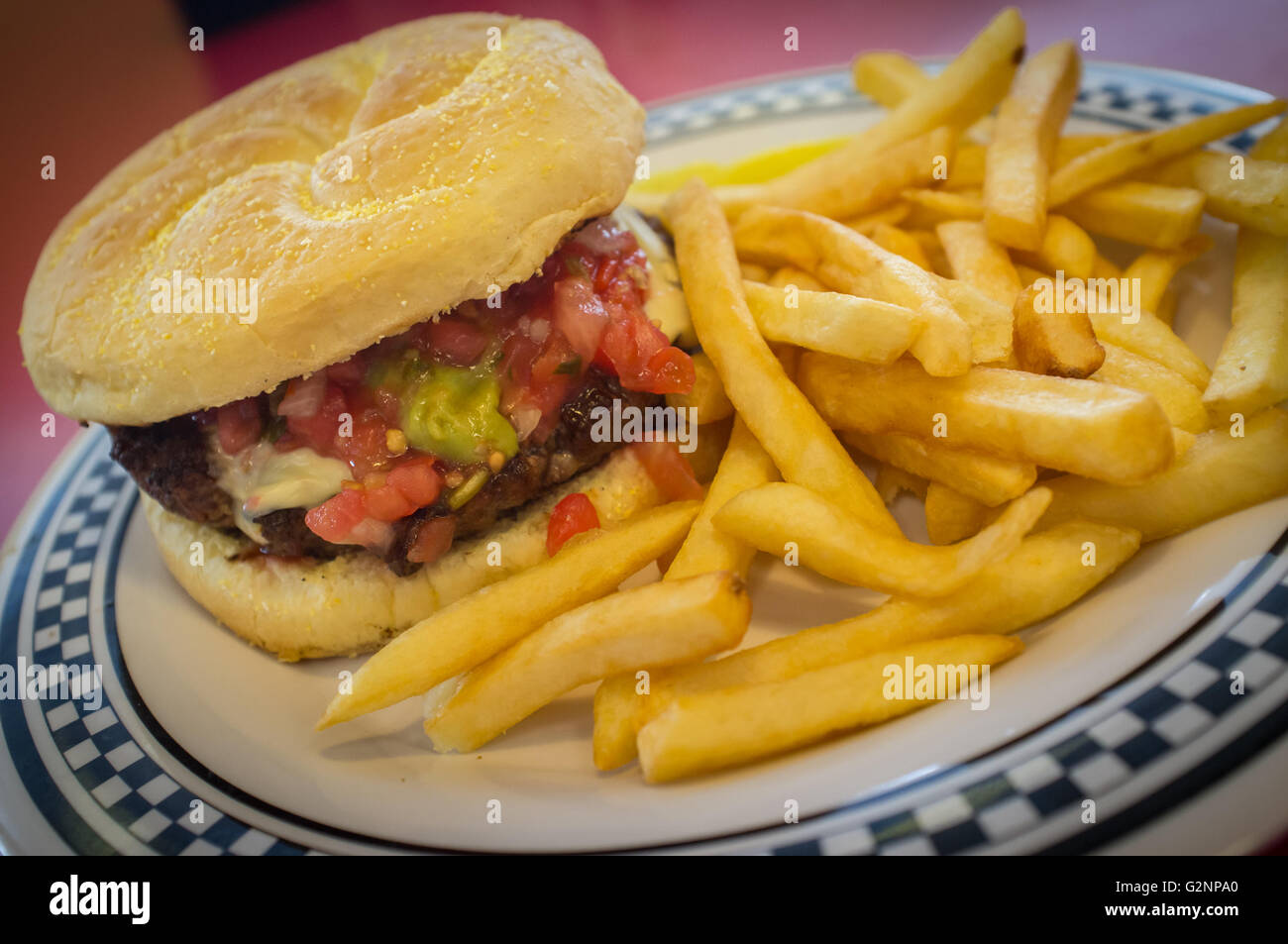 Cheeseburger on a kaiser roll with steak fries on the side Stock Photo