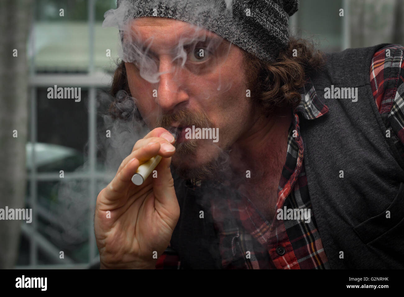 Long Haired Bearded Man Smokes A Vape E Cigarette Stock Photo