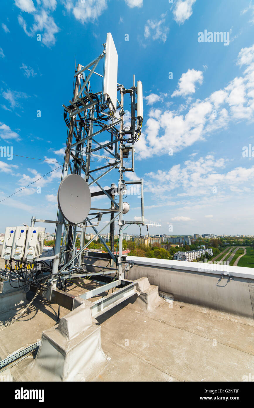 communications mast with antennas on the roof of an office building Stock Photo