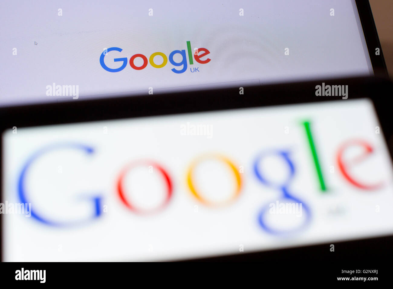 Google UK search engine logos are pictured on phone and laptop screens ...