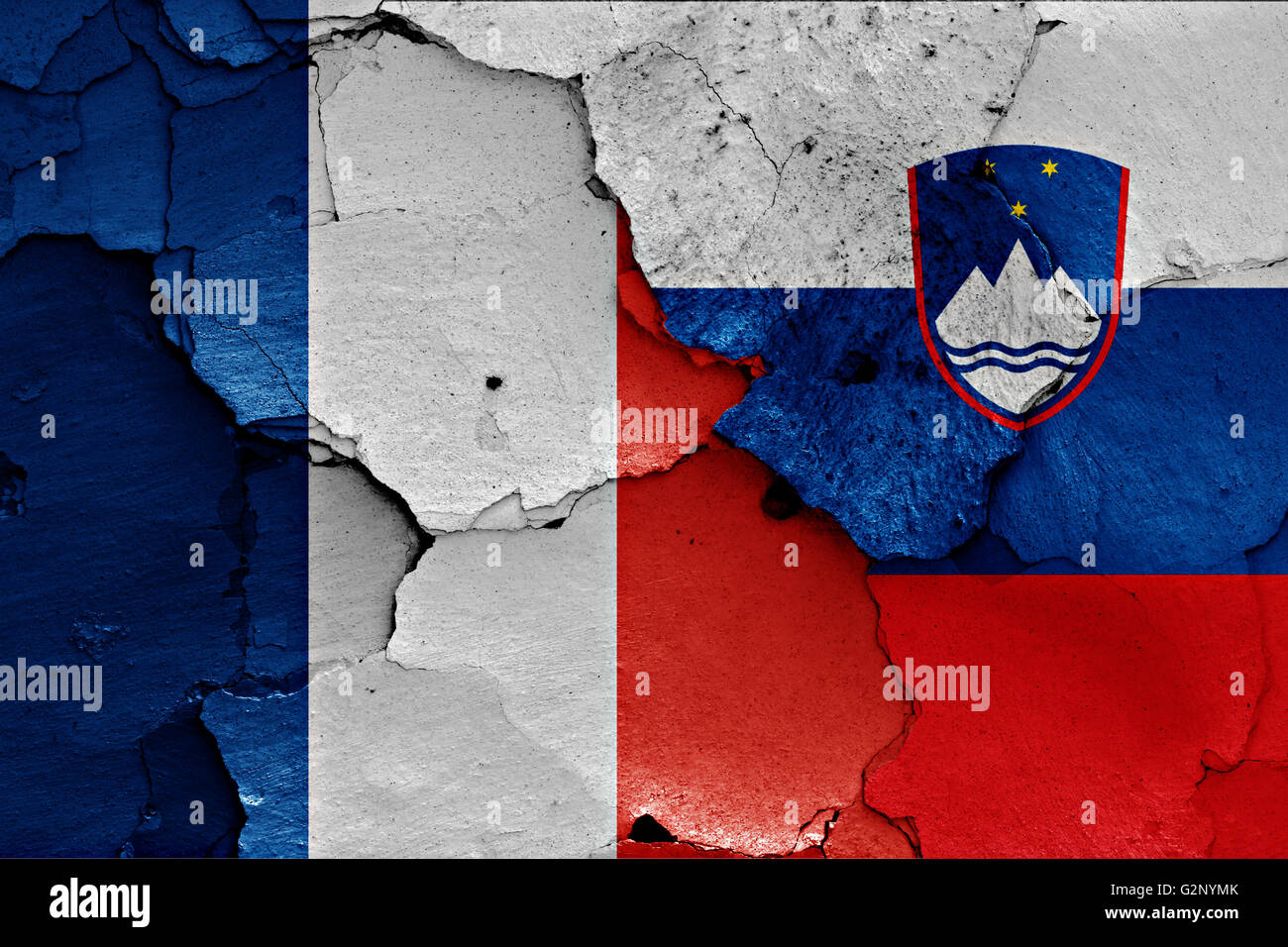flags of France and Slovenia painted on cracked wall Stock Photo