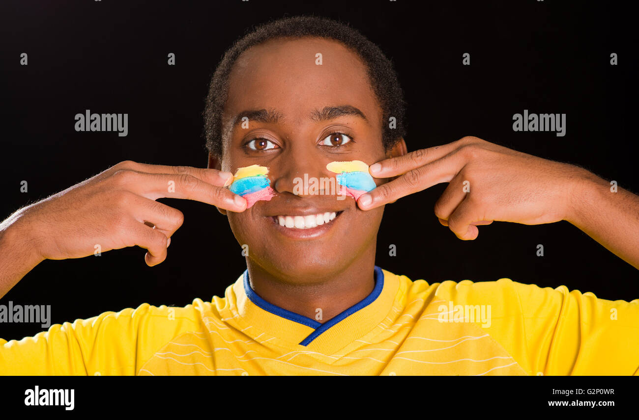 Headshot Dark Skinned Male Wearing Yellow Football Shirt In Front Of Black Background Using