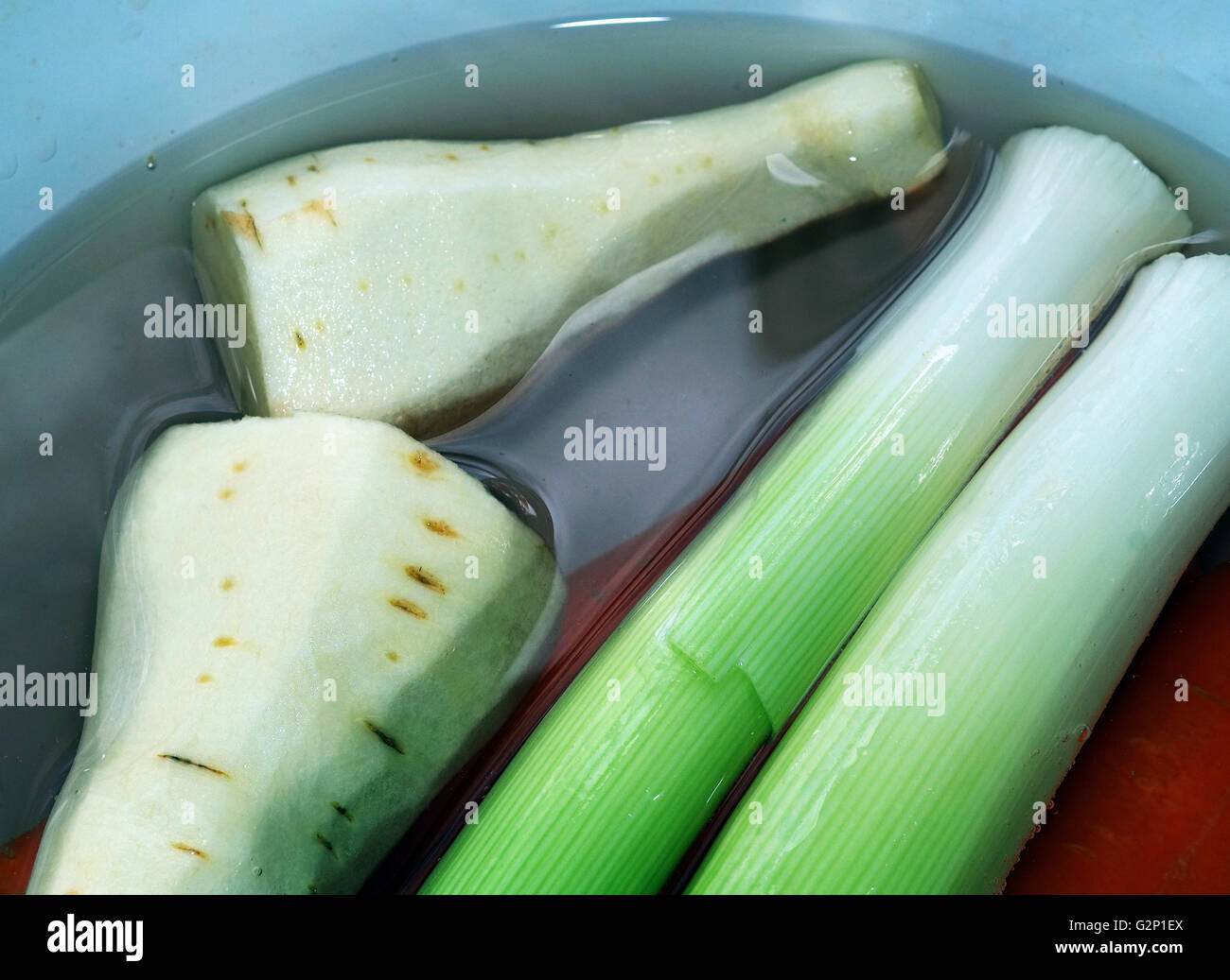 Leaks and parsnips in water ready to cook. Stock Photo