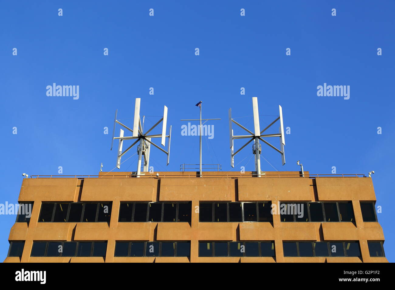 Wind turbines generate electricity atop an office building in the downtown CBD of Hobart, Tasmania, Australia. Stock Photo
