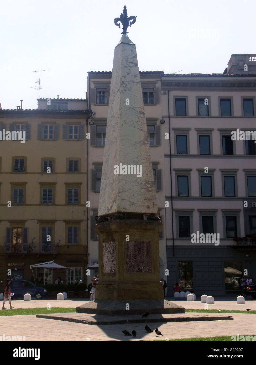 The Obelisk at Santa Maria Novella. Florence, Italy. An obelisk is a tall, four-sided narrow tapering monument, which ends in a pyramid shaped point on top. This marble obelisk stands atop 4 sculpted turtles on a platform. Stock Photo