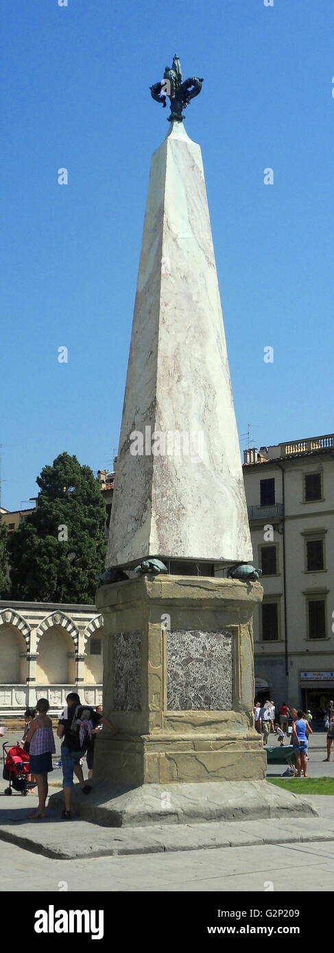The Obelisk at Santa Maria Novella. Florence, Italy. An obelisk is a tall, four-sided narrow tapering monument, which ends in a pyramid shaped point on top. This marble obelisk stands atop 4 sculpted turtles on a platform. Stock Photo