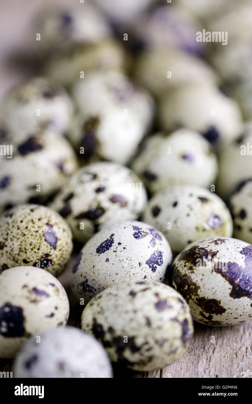 Frsh whole Quail Eggs wooden board on table Stock Photo