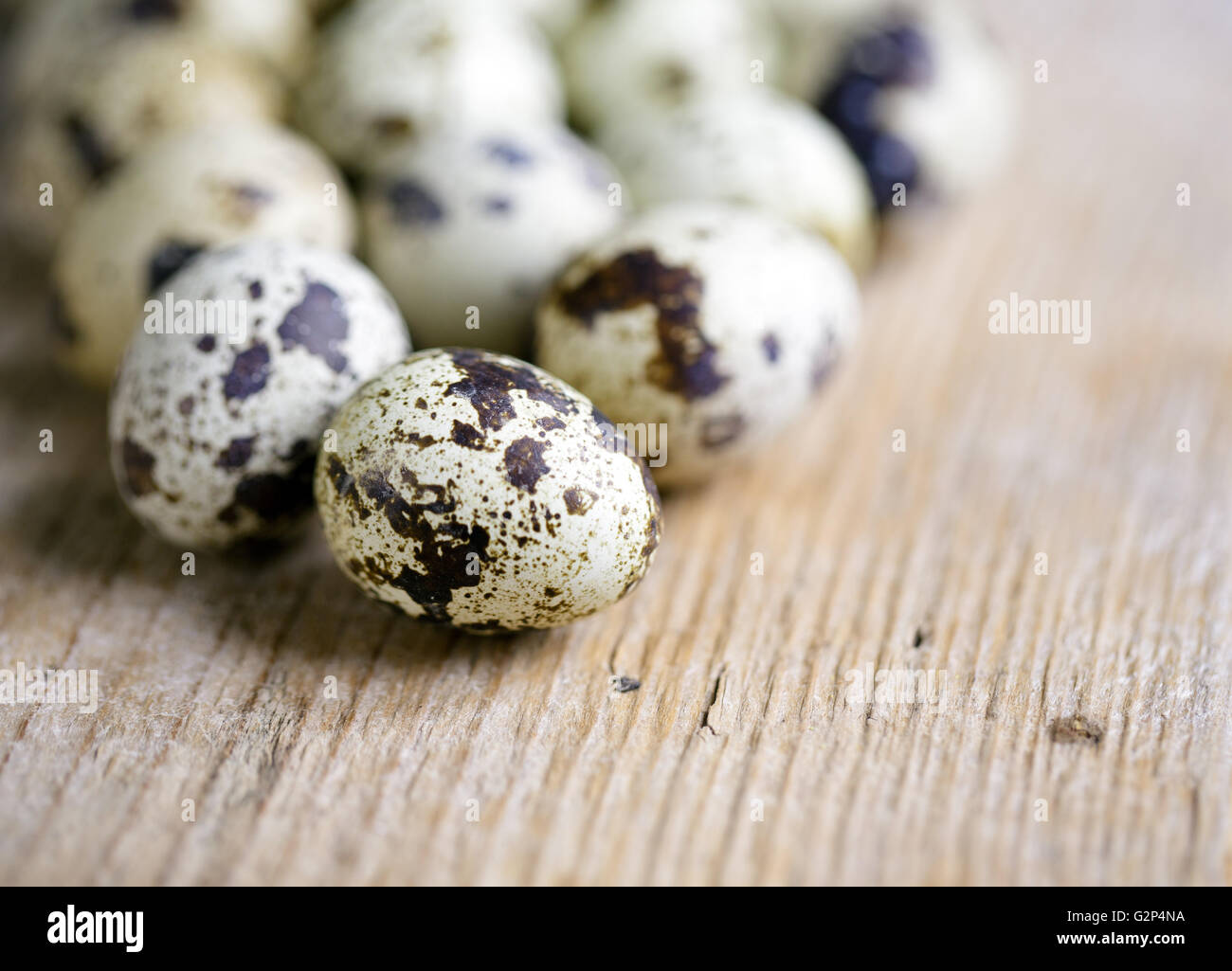 Frsh whole Quail Eggs wooden board on table Stock Photo