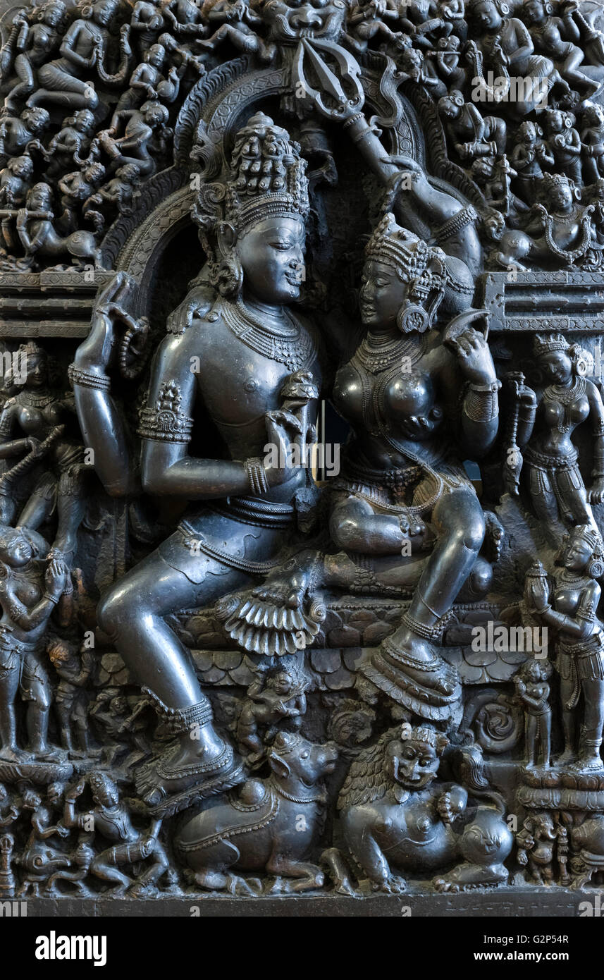 Shiva and Parvati, Orissa, India, 12thC-13th century. A stone figure of 'Hara-Pārvatī' (Śiva seated with Pārvatī on his knee), also known as Umamahesvaramurti, accompanied by a lion and a bull (Nandi) and surrounded by many flying and standing attendants. Displayed in the British Museum, Bloomsbury, London, UK Stock Photo
