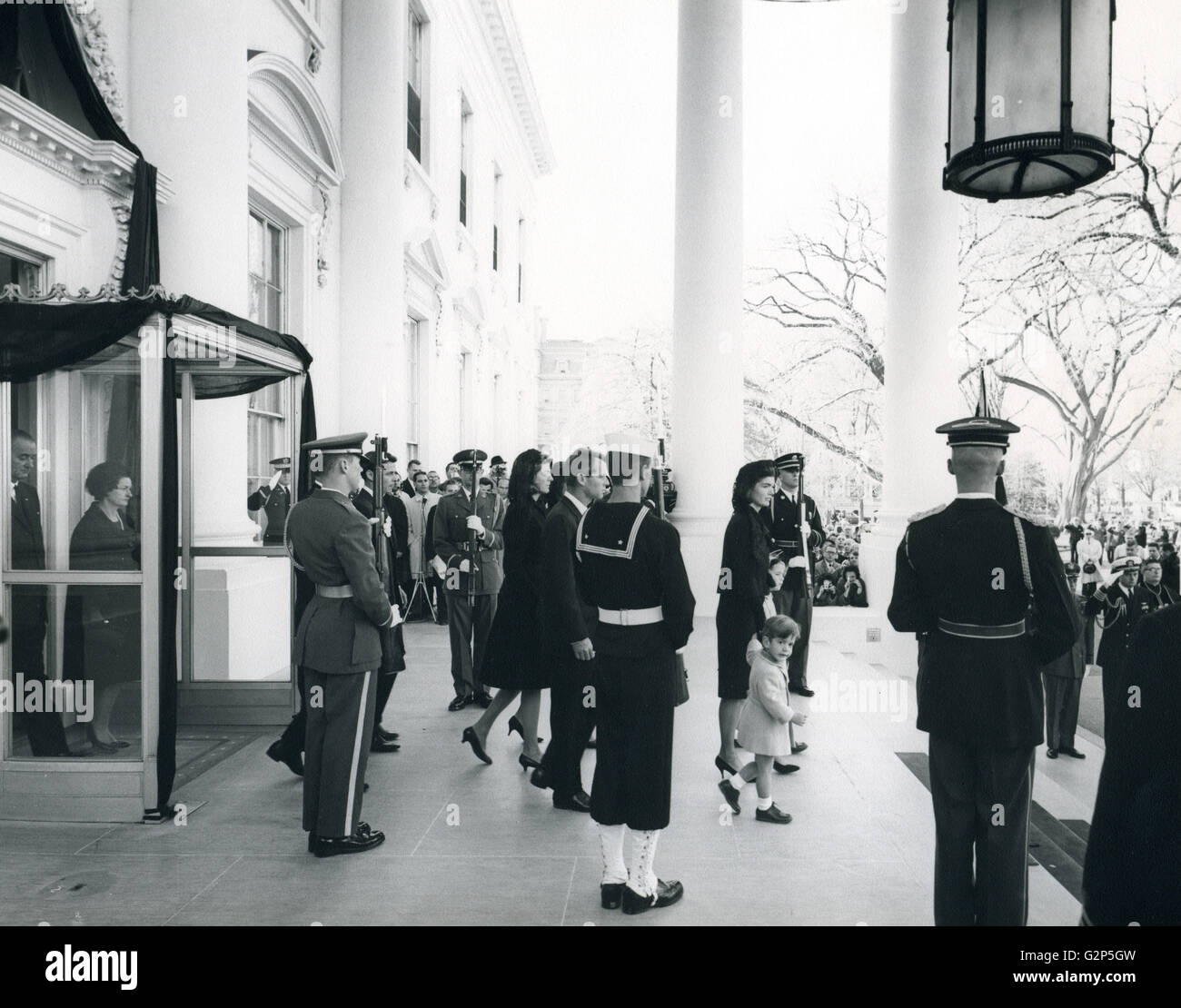 The Kennedy family leaves the White House to attend the brief service at the U.S. Capitol. President and Mrs. Johnson follow. Abbie Rowe photographer. Stock Photo