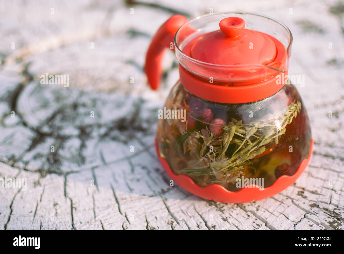 teapot of fruit tea with herbs and berry on the white tree stump Stock Photo Alamy