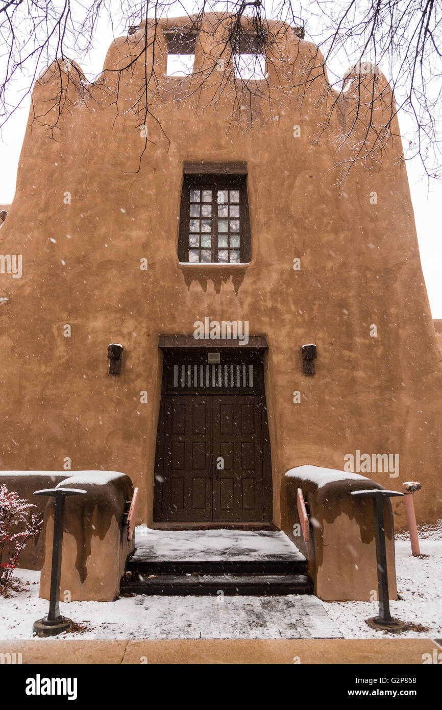 Snow covers the adobe style New Mexico Museum of Art in the historic
