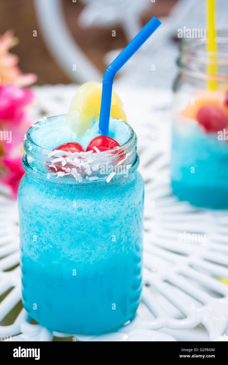 Blue cocktail drink with cherries and straw in mason jar Stock Photo