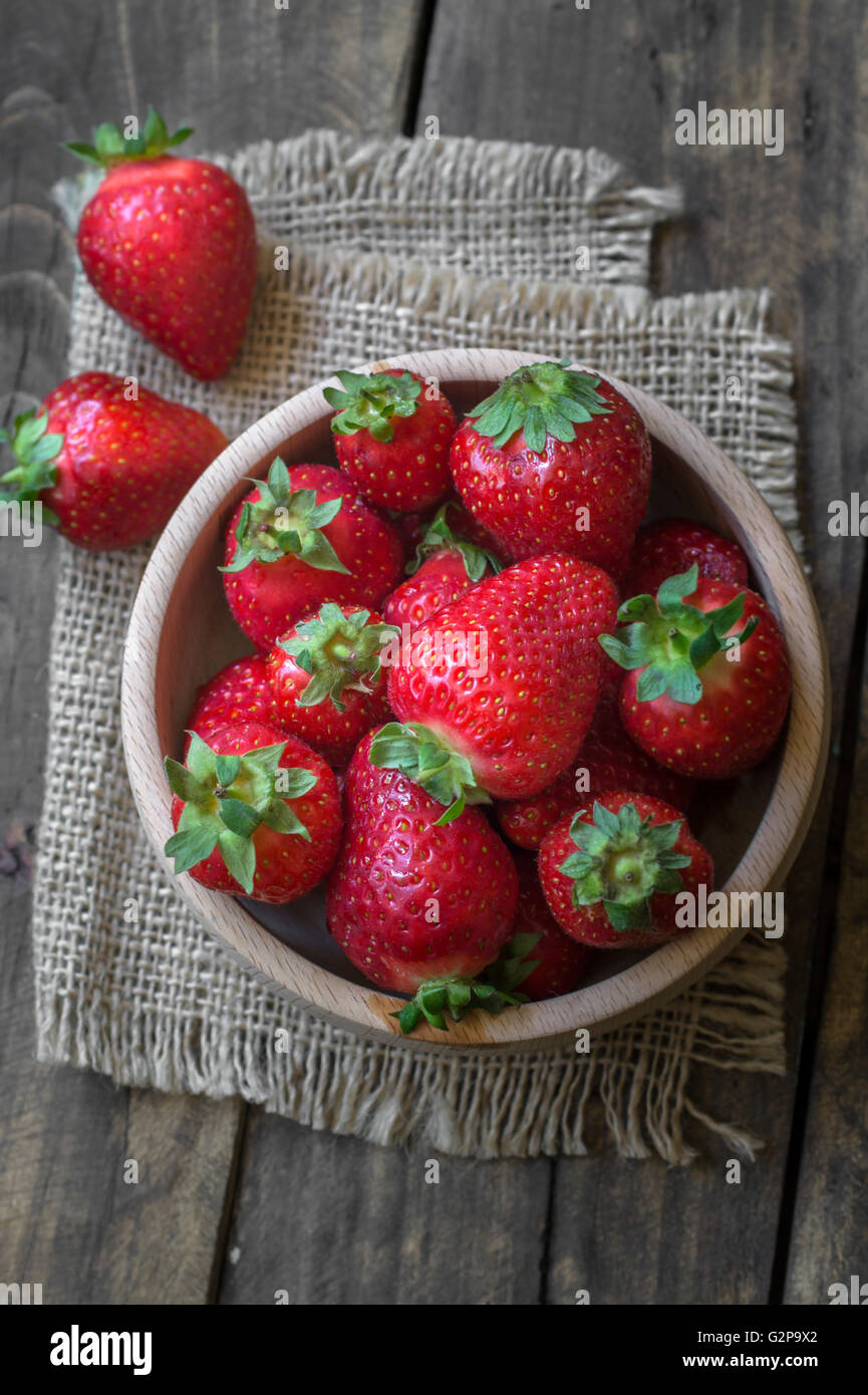 Wooden  bowl filled with fresh ripe red strawberries, from above Stock Photo
