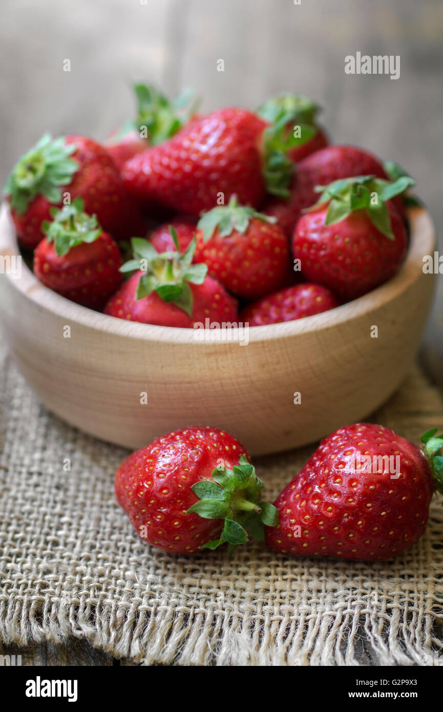Wooden  bowl filled with fresh ripe red strawberries, close up Stock Photo