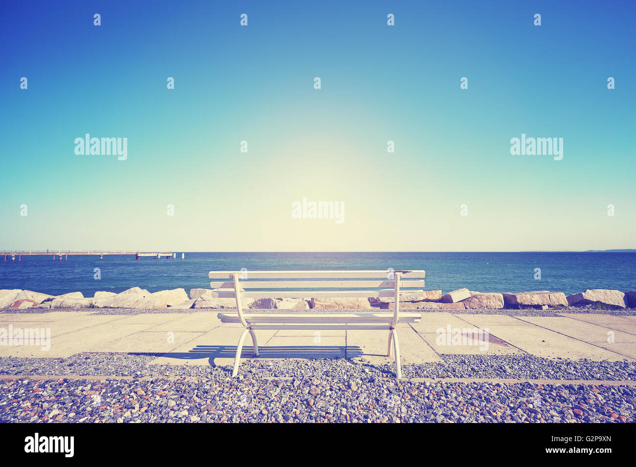 Vintage toned empty bench against the sun, space for text. Stock Photo