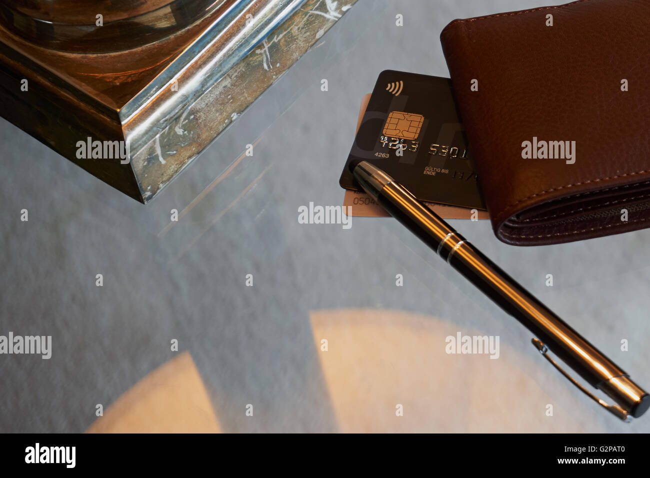 Credit Card, desk lamp and pen on glass table Stock Photo