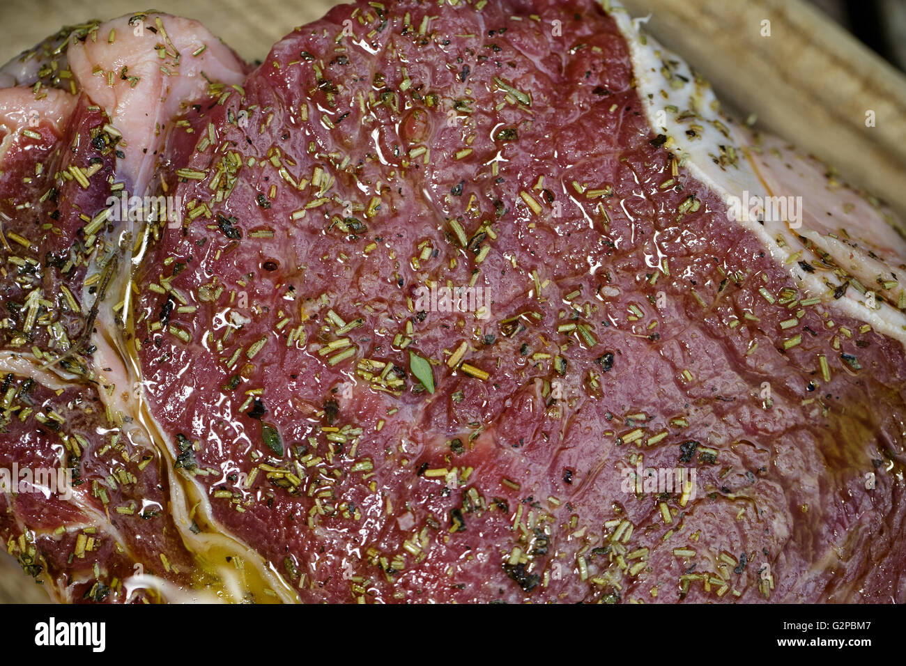 Large Fresh raw beef cutlet with spices on wooden board, ready for the grill Stock Photo