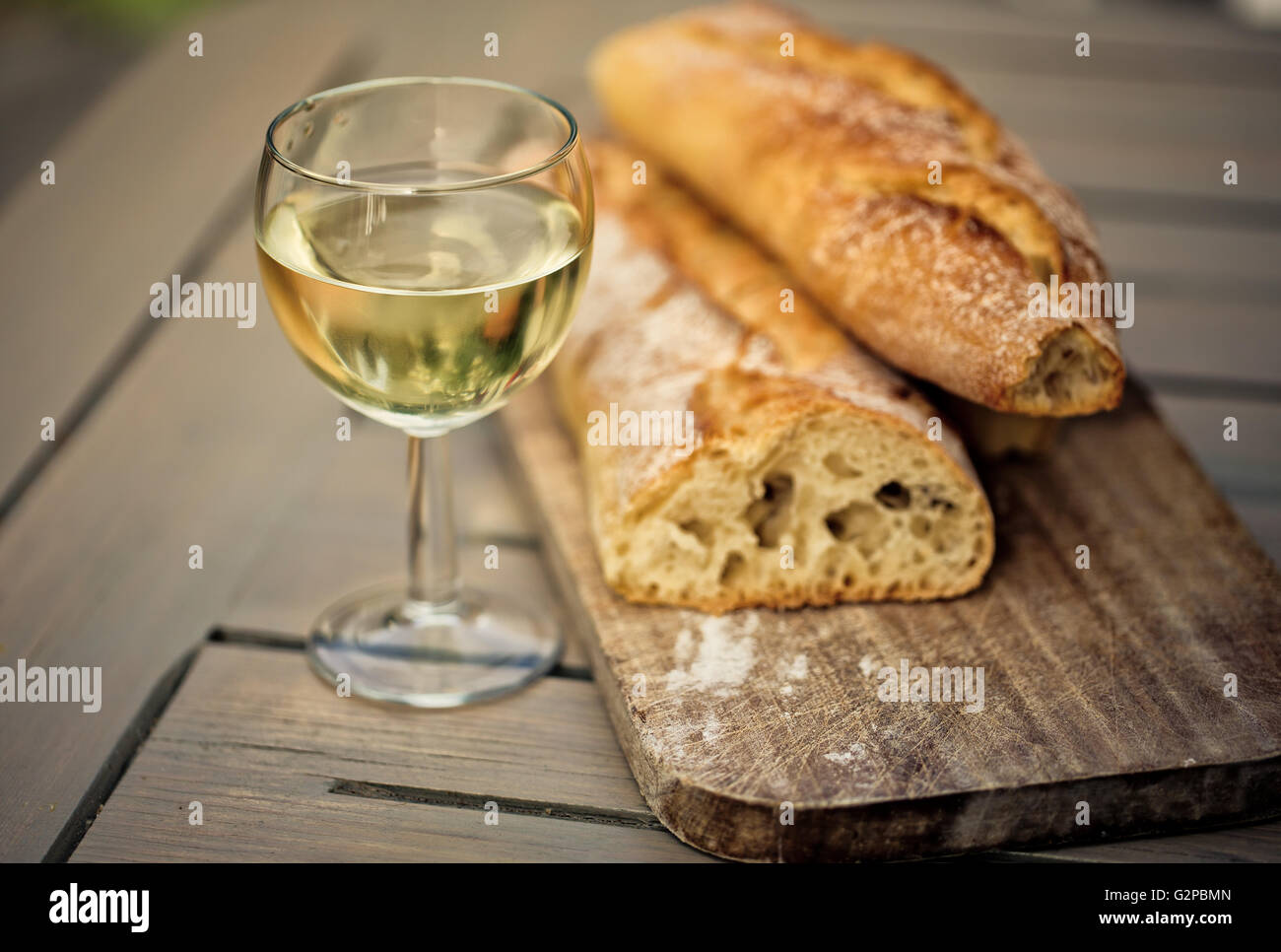 White French Bread on Wooden board with  glass of White Wine Stock Photo