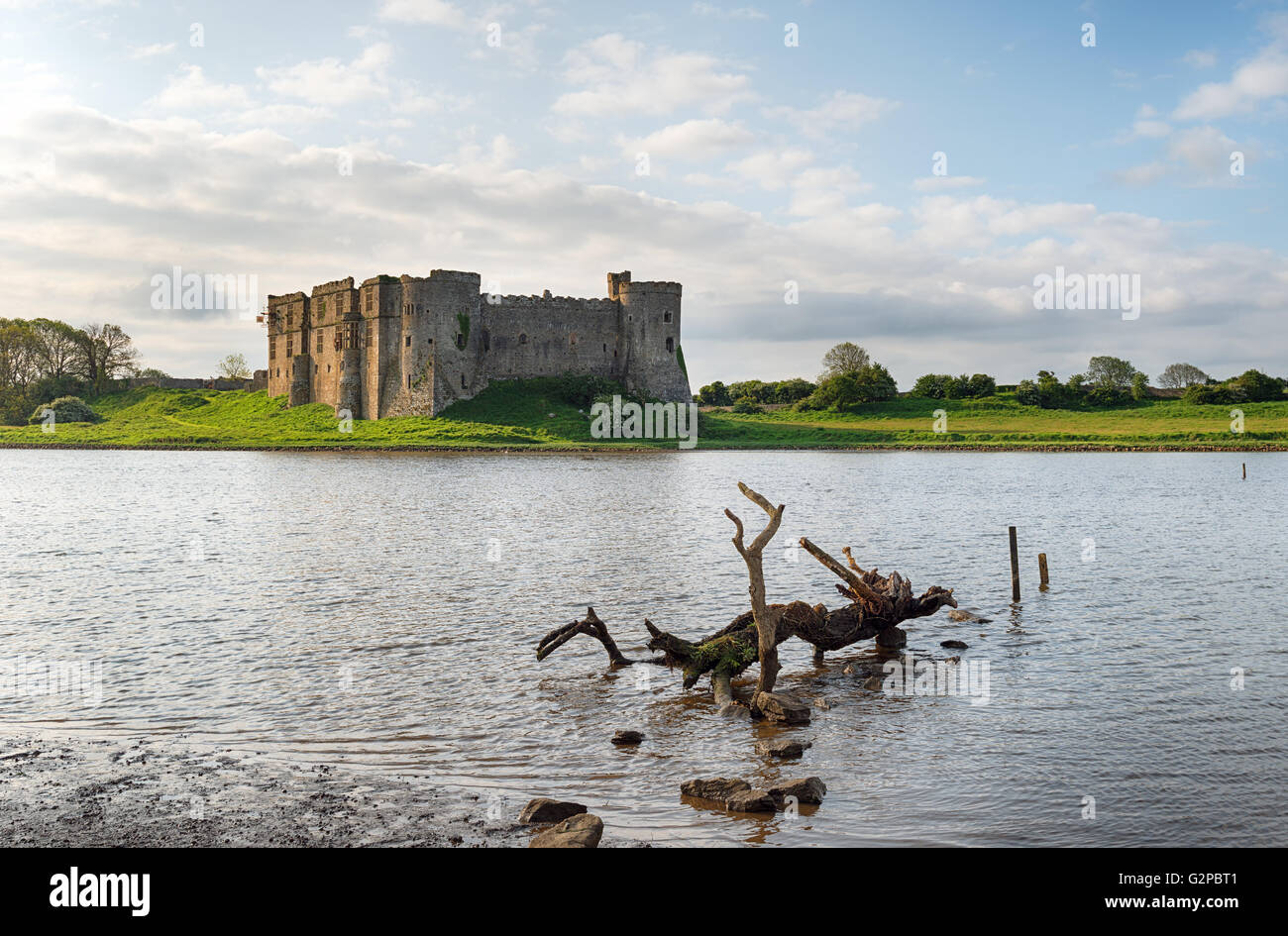 Carew castle on the banks of an inlet of the Carew River in Pembrokeshire, Wales Stock Photo