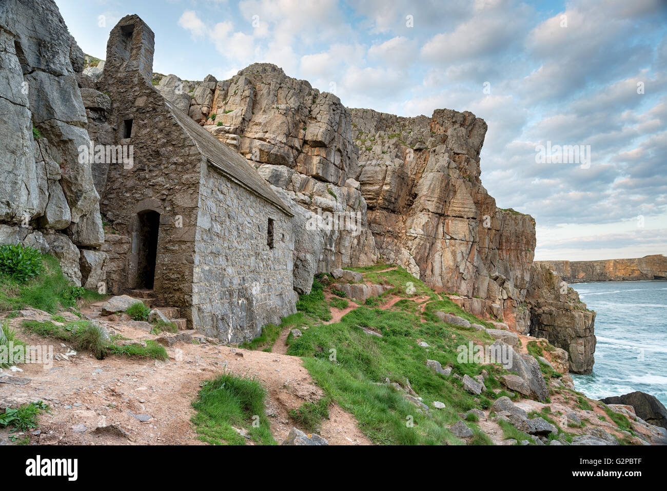 St Govan's Chapel, a tiny medieval hermit cell built in to the cliffs on a rugged stretch of coastline at Pembrokeshire in Wales Stock Photo